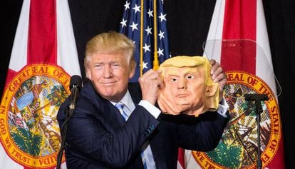 Donald Trump muestra una máscara de sí mismo en un mitin electoral . /