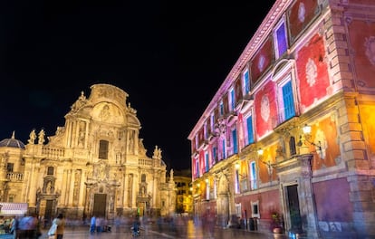 La fachada barroca de la catedral de Murcia (al fondo) y el Palacio Espiscopal (en primer término), iluminados de noche.