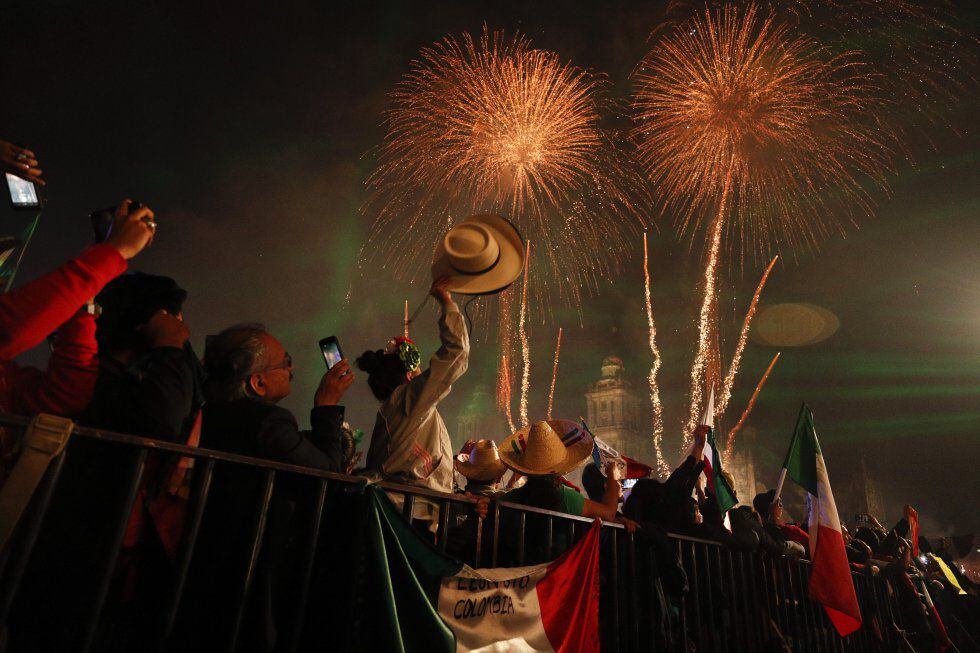 Un grupo de personas observa los fuegos artificiales después del grito de independencia en el Zócalo de Ciudad de México.