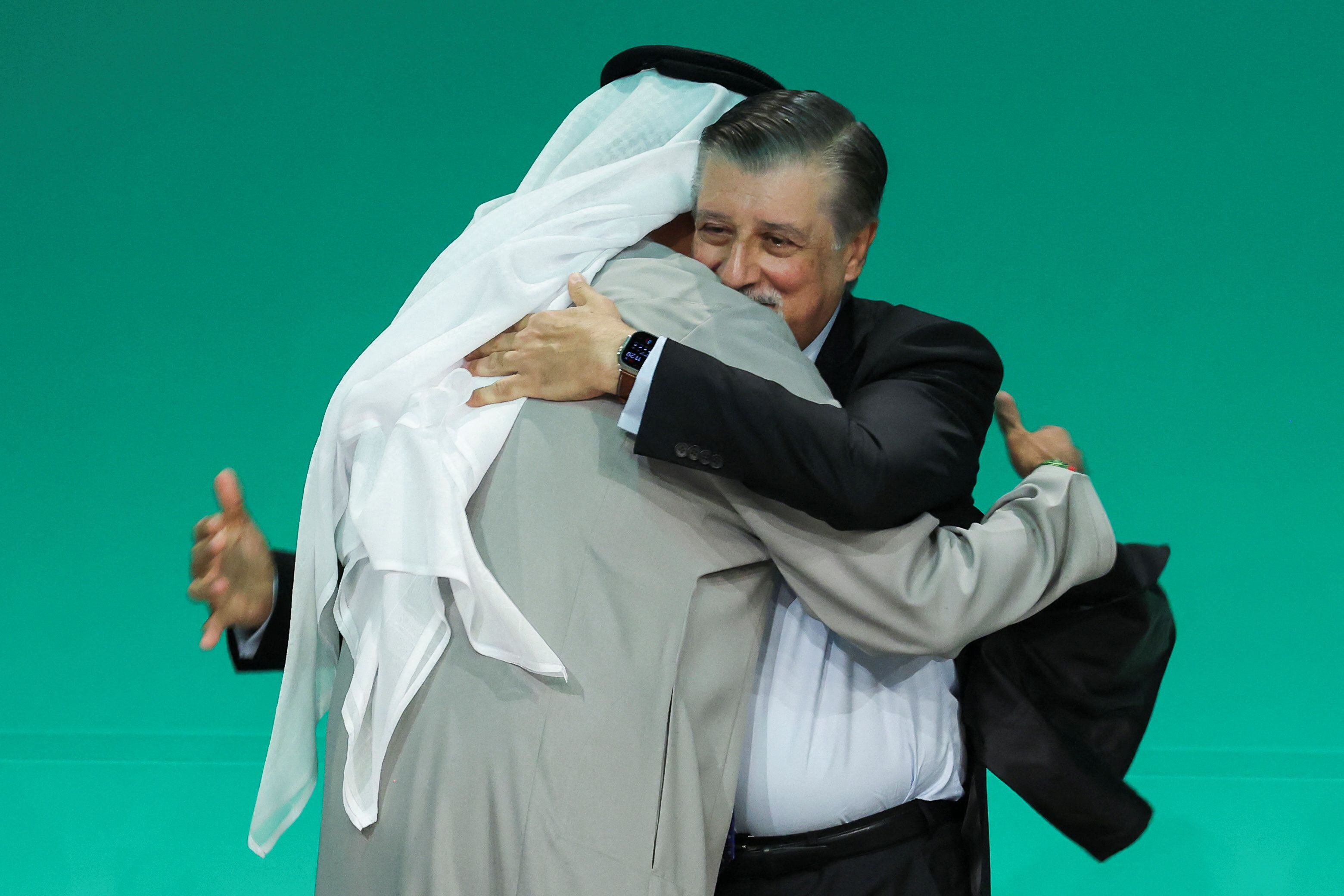Sultán Ahmed Al Jaber abraza a Adnan Amin, director ejecutivo de la COP28, este miércoles en la sesión plenaria celebrada en Dubái.