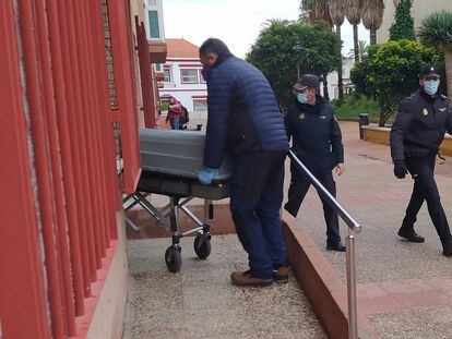 Trabajadores del tanatorio retiran el cuerpo sin vida de la mujer asesinada en Ceuta, este lunes.
