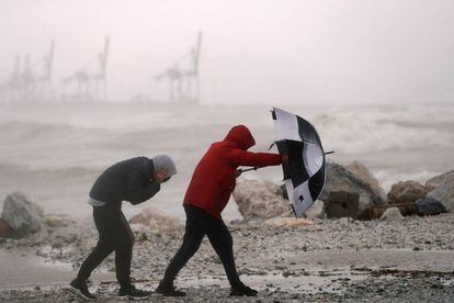 Un hombre con un paraguas se protege del fuerte viento en la playa Seacaba de Málaga, el 8 de enero.