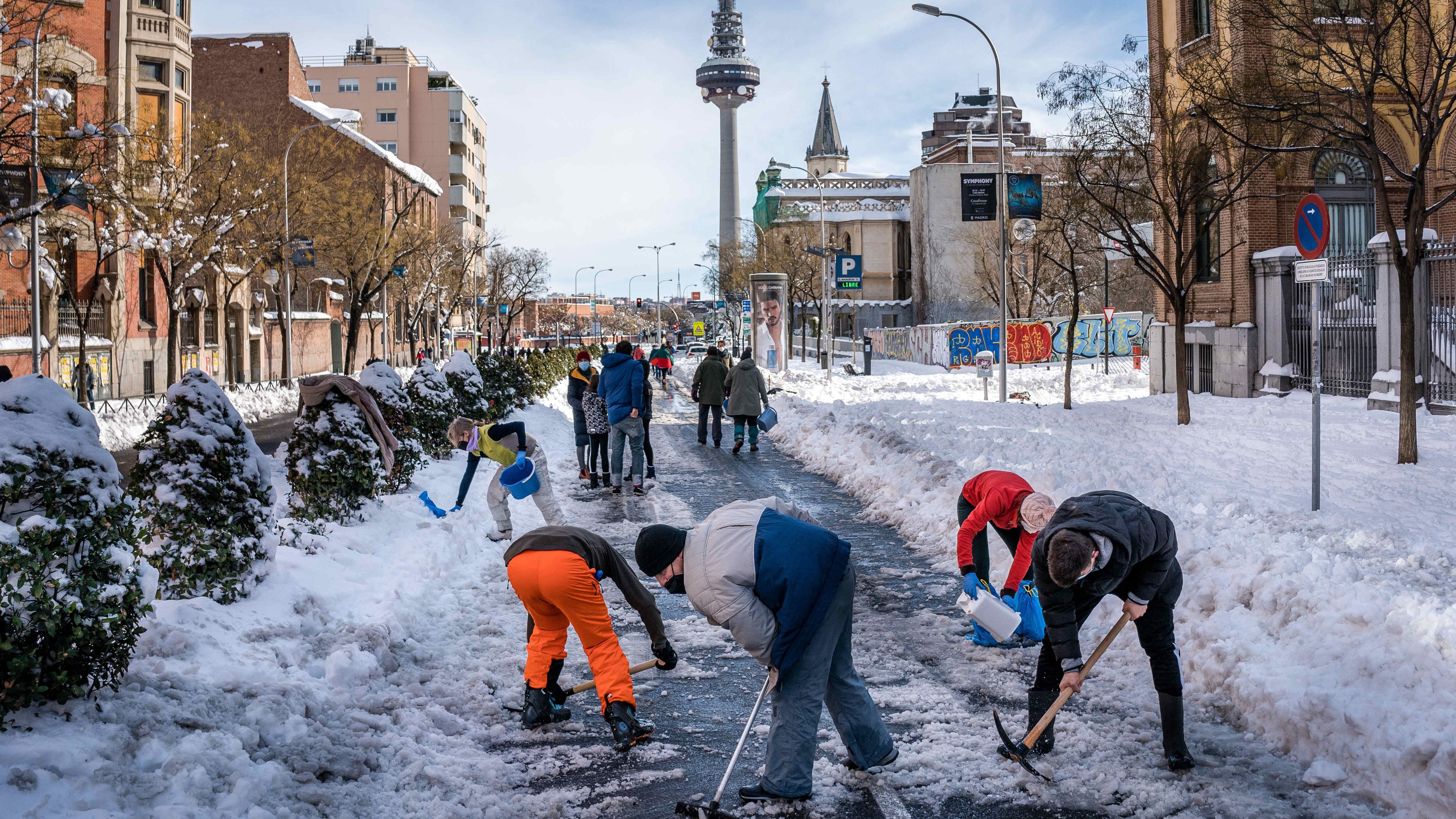 Trabajadores y vecinos de Madrid limpiando las calles de nieve tras el paso de Filomena.