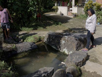 Residentes de Valle Encantado junto a un arroyo con agua de manantial y apto para la piscicultura.