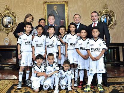 Juan Manuel Santos y Florentino Pérez en el Palacio Presidencial de Bogotá junto a los niños que participan en el proyecto solidario