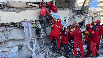 Rescatistas llevan a una mujer después de ser evacuada de debajo de un edificio derrumbado tras un terremoto, en Turquía, 7 de febrero.