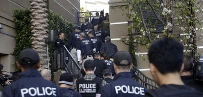 Agentes federales entrando en un complejo de apartamentos de lujo en Irvine, al sur de Los Ángeles, el martes por la mañana.