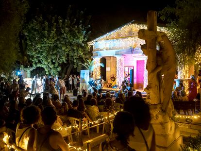 Varias personas disfrutan de un concierto, bailan y caminan junto a algunas de las tumbas en el Cementerio Inglés de Málaga, que durante las noches de verano programa una intensa agenda cultural y muestra sus tumbas bajo una iluminación artística.