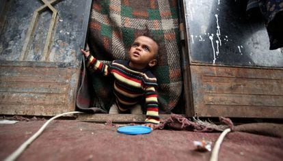 Un niño yemení desplazado desde Hodeida por la guerra gatea en la puerta de la choza de Sanaa, la capital del país, donde se ha refugiado su familia, en Sanaa, Yemen.