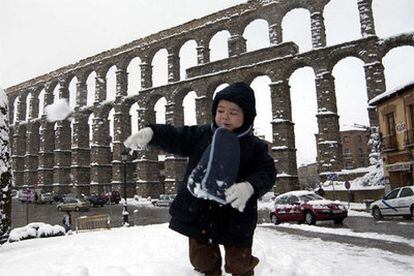 Un niño juega con la nieve en la capital segoviana.