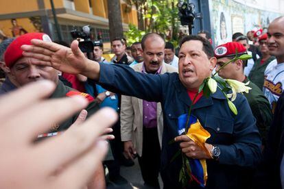 El presidente de Venezuela, Hugo Chávez, saluda a sus seguidores tras depositar su voto en un colegio de la zona popular del 23 de Enero.