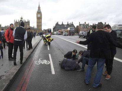 Diverses persones assisteixen un dels ferits al pont de Westminster.