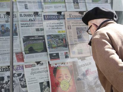 Un señor observa portadas de varios periódicos en un kiosco en San Sebastián.