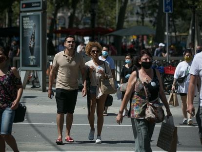Varias personas con y sin mascarilla en el centro de Barcelona.