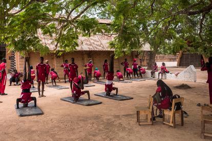 The school has two fields for sports practice.  In the image, several students do gymnastics.