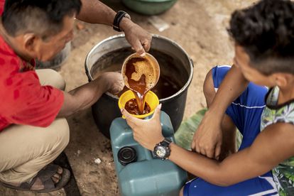 Un chamán sirve la preparación de ayahuasca a un cliente, en Pucallpa (Perú), en 2018.