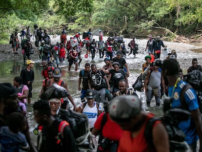 Un grupo de migrantes cruza un río en la selva del Darién, cerca de Acandí, en Colombia, el 7 de octubre de 2021.