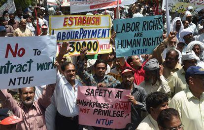 Trabajadores paquistaníes portan pancartas durante la manifestación del 1 de Mayo en Lahore.