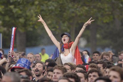 A France supporter wearing a national flag gestures at the fan zone, near the Eiffel tower in Paris on June 10, 2016 ahead of the start of the Euro 2016 football championship.   AFP PHOTO / ALAIN JOCARD