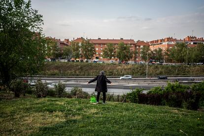Un hombre mira la M-40 desde una zona de jardines en Ciudad de los Ángeles, en el distrito de Villaverde de Madrid.