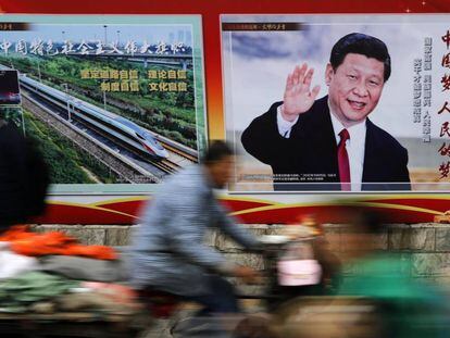 Varias personas pasan delante de un cartel del presidente chino, Xi Jinping, en Pekín, el pasado 26 de octubre.