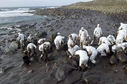 Un grupo de voluntarios recoge chapapote en los alrededores del cabo de Touriñán (A Coruña).