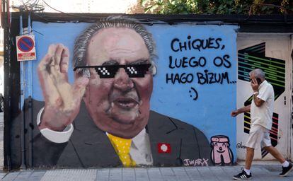 Un hombre pasa por delante de un grafiti realizado por el artista valenciano J.Warx, en agosto de 2022.