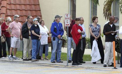 Varias personas esperan en fila para ejercer su derecho al voto en un colegio electoral en Miami.