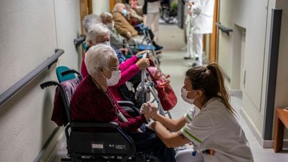 Una enfermera atiende a personas mayores antes de vacunarse.