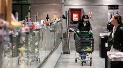 Varias personas hacen la compra en un supermercado en Madrid.