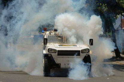Un vehículo blindado de la policía antidisturbios trata de dispersar a los manifestantes durante la protesta en contra del gobierno de Nicolás Maduro, en Caracas (Venezuela).