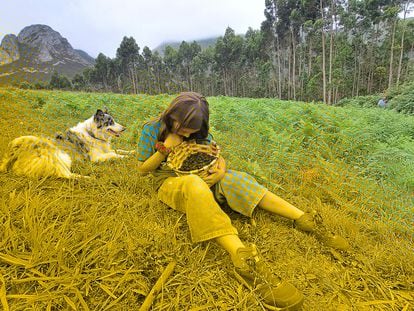 Una niña recoge moras acompañada de su perro en un monte cerca de Ribadesella, Asturias.