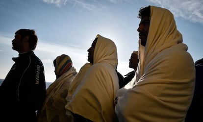 Migrantes rescatados frente a Libia en ruta a Italia observan la costa de Sicilia, el 10 de mayo.