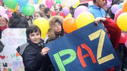 Unos niños portan un cartel por la paz en la suelta de globos de Bilbao en 2019.
