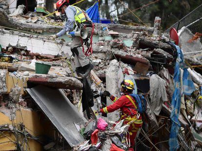 Dos rescatistas trabajan en un derrumbre de la Ciudad de México.