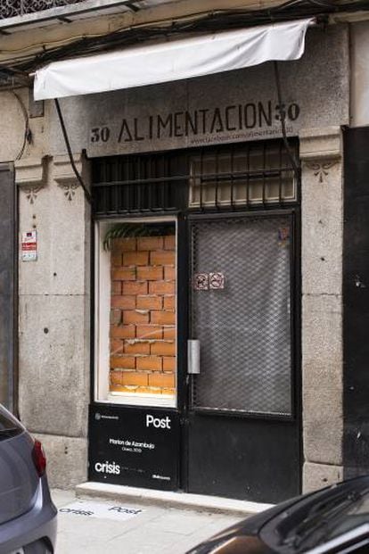 Marlon de Azambuja ha tapiado un escaparate de Lavapiés, por cuyas juntas escapan hojas verdes.