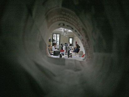 La redacció d'El 9 Nou, a Vic, vista des d'un forat format amb un diari.