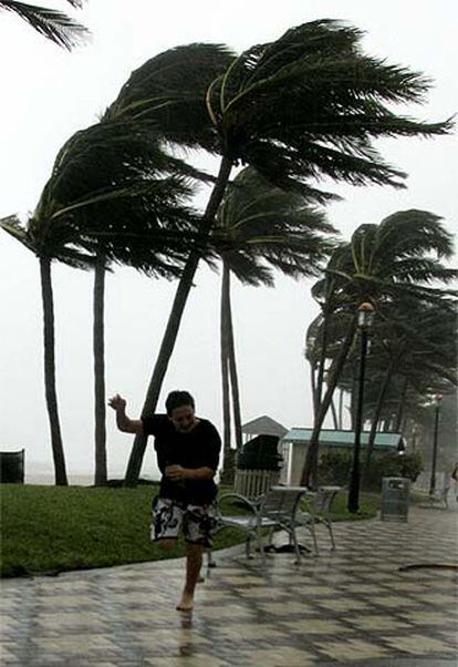 Dos hombres huyen de los fuertes vientos al paso del ciclón Katrina por Deerfield, en Florida.