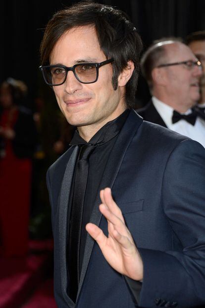 Gael García Bernal, con gafas a lo Eugenio, y traje azul marino.