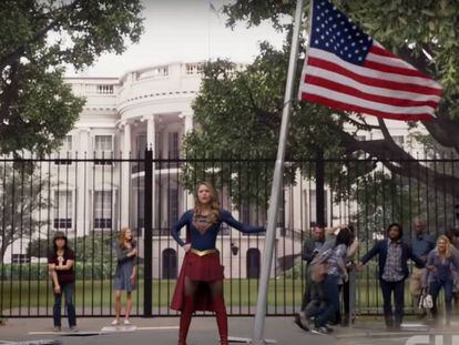 Supergirl con una bandera de EE UU frente a la Casa Blanca.