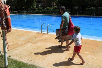 Un adulto y un niño en una piscina comunitaria de Majadahonda (Madrid), en junio de 2020.