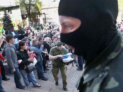 Activistas prorrusos guardan la entrada de la televisi&oacute;n regional en Donetsk. 