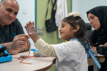 Miira, a punto de cumplir cinco años, y su tía Amna, ambas de Gaza, en la sala de fisioterapia ocupacional del Hospital de Cirugía Reconstructiva de Amán. Miira se quemó torso, brazos y manos con tan solo 8 meses en una visita a su familia en Egipto.