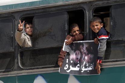 Niños palestinos llevan una pancarta con la leyenda "Rescate a Gaza".