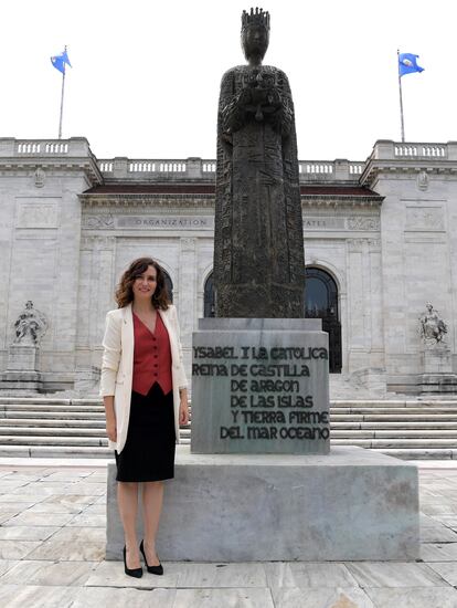 La presidenta de la Comunidad de Madrid, Isabel Díaz Ayuso, posa junto a una estatua de la reina Isabel I de Castilla, frente a la sede de la Organización de Estados Americanos (OEA), en Washington (Estados Unidos).