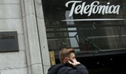 Un usuario habla por el móvil junto a la sede de Telefónica en Gran Vía.