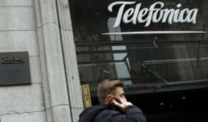 Un usuario habla por el m&oacute;vil junto a la sede de Telef&oacute;nica en Gran V&iacute;a.