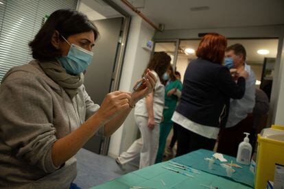 Personal sanitario prepara y administra la vacuna de la covid-19 a sus compañeros en el hospital Vall d'Hebrón de Barcelona.
