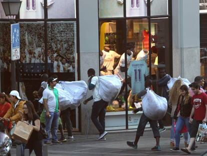 Unos recogen su mercanc&iacute;a en el centro de Madrid.