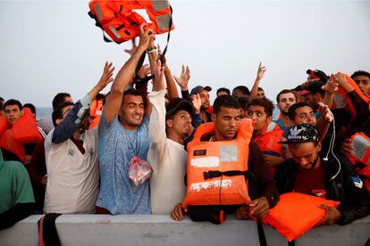 Migrantes reciben con júbilo chalecos salvavidas durante una operación de búsqueda y rescate de Open Arms en el Mediterráneo central, el pasado 17 de agosto. 